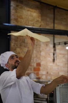 head pizza chef tossing dough